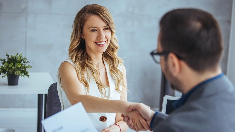 A handshake between two people in the office to illustrate internal mobility.